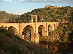 Puente de arco de piedra cruzando un valle